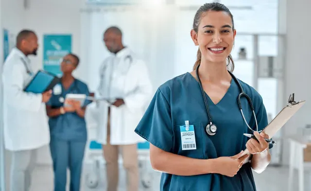 Nurse in Green Scrubs Smiling While Holding Clipboard